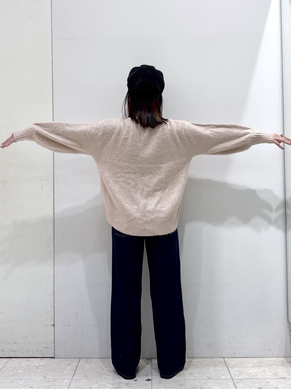 ベージュ系のダウンジャケット/コート、ピンク系のニット/セーター、ブルー系のデニムパンツを着用したレディースの冬コーディネートの8枚目の写真