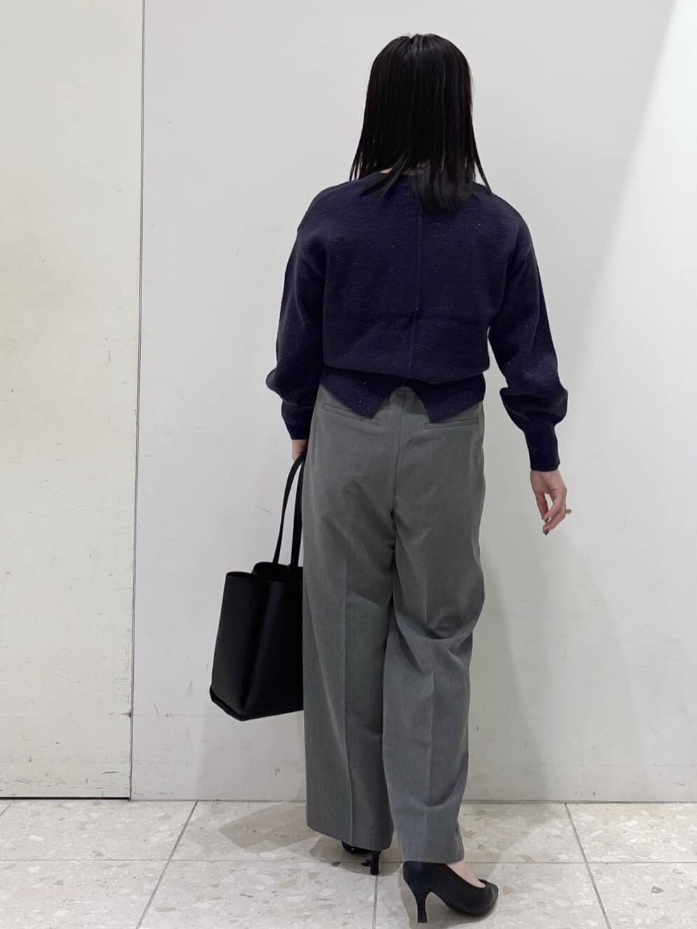 ブルー系のニット/セーター、グレー系のその他パンツ、ブラック系のトートバッグを着用したレディースの冬コーディネートの3枚目の写真