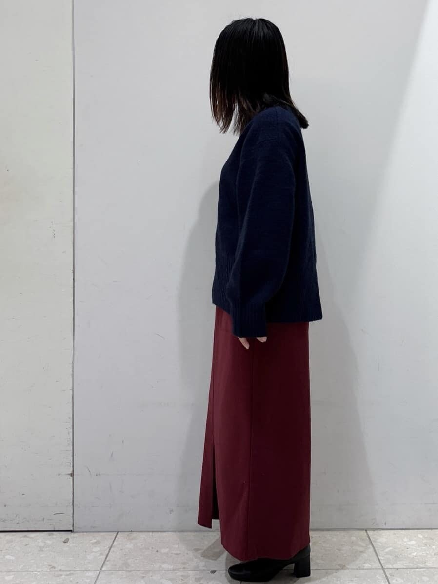 ブルー系のニット/セーター、レッド系のスカート、ブラック系のショルダーバッグを着用したレディースの冬コーディネートの4枚目の写真