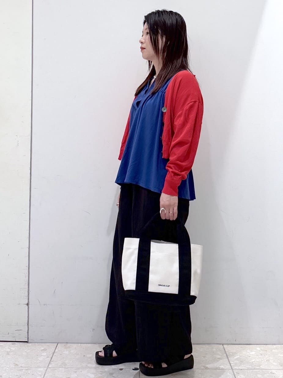 レッド系のカーディガン/ボレロ、ブルー系のTシャツ/カットソー、ホワイト系のタンクトップを着用したレディースの夏コーディネートの6枚目の写真