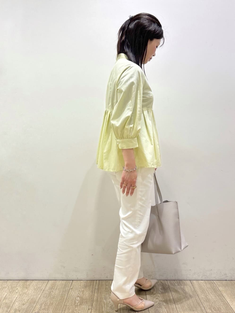 ベージュ系のパンプス、グレー系のトートバッグ、ホワイト系のその他パンツを着用したレディースの春コーディネートの2枚目の写真