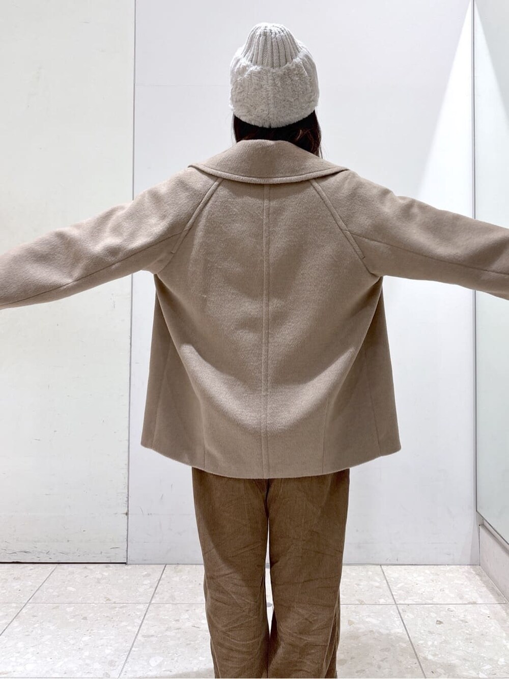 ベージュ系のピーコート、レッド系のカーディガン/ボレロ、イエロー系のその他パンツを着用したレディースの冬コーディネートの5枚目の写真