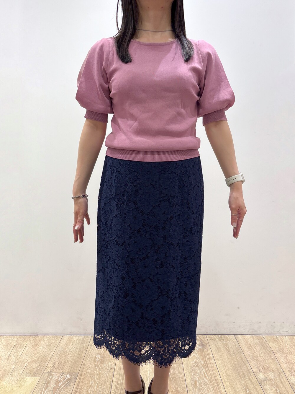 ピンク系のニット/セーター、ブラック系のトートバッグ、レッド系のパンプスを着用したレディースの夏コーディネートの6枚目の写真