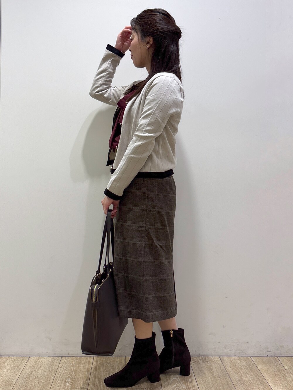 ベージュ系のカーディガン/ボレロ、レッド系のシャツ/ブラウス、ブラウン系のスカートを着用したレディースの秋コーディネートの4枚目の写真