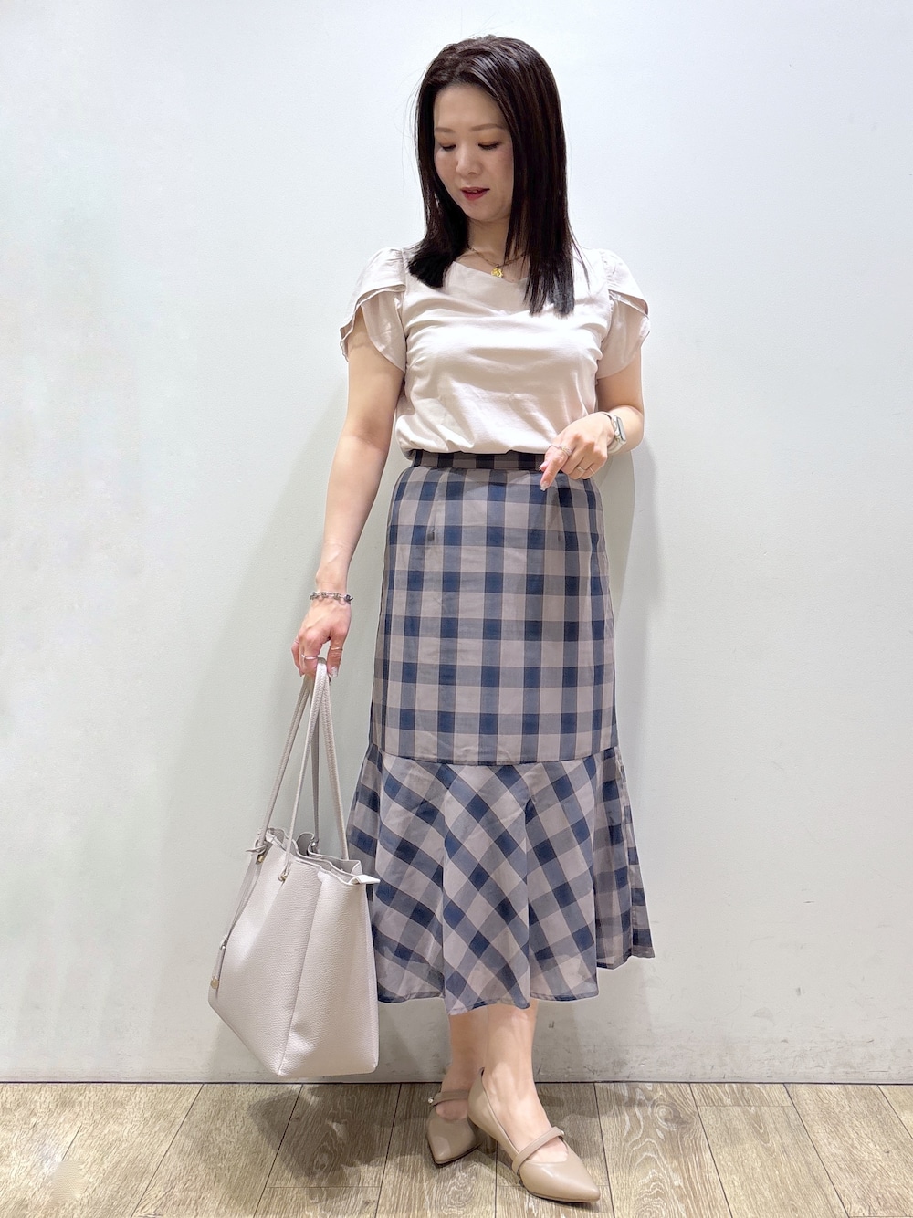 ベージュ系のTシャツ/カットソー、ブラウン系のスカート、グレー系のトートバッグを着用したレディースの夏コーディネートの2枚目の写真