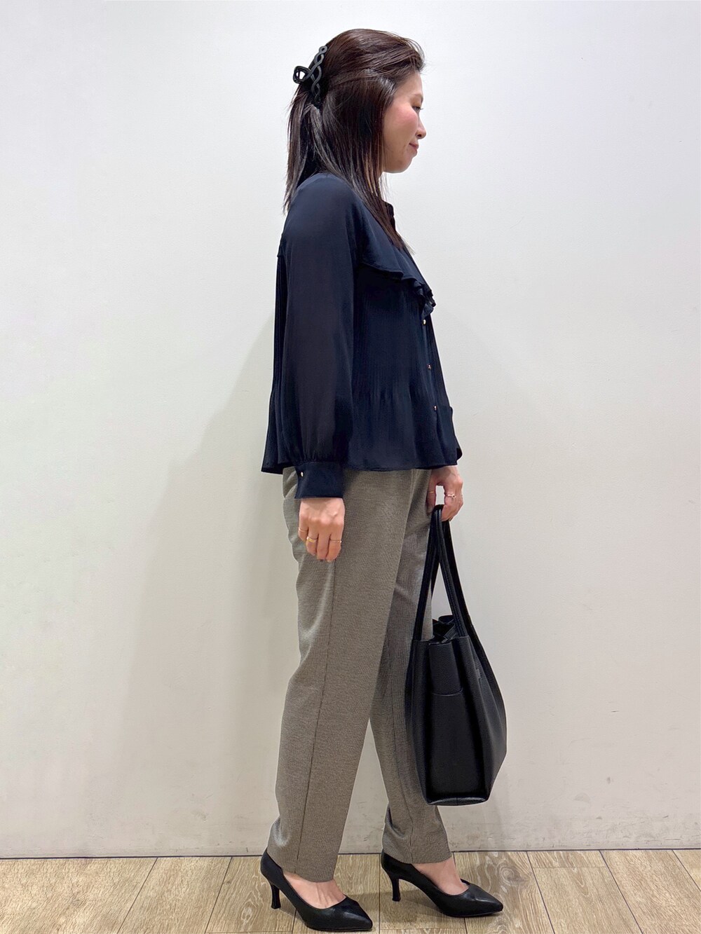 ブルー系のシャツ/ブラウス、ブラック系のその他パンツ、ブラック系のトートバッグを着用したレディースの秋コーディネートの4枚目の写真