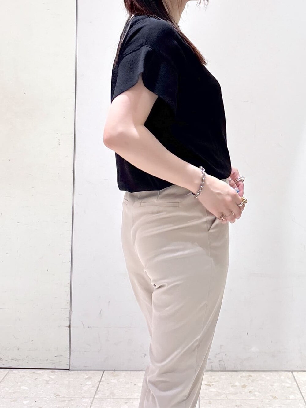 ブラック系のニット/セーター、ベージュ系のその他パンツ、ブラック系のトートバッグを着用したレディースの夏コーディネートの6枚目の写真