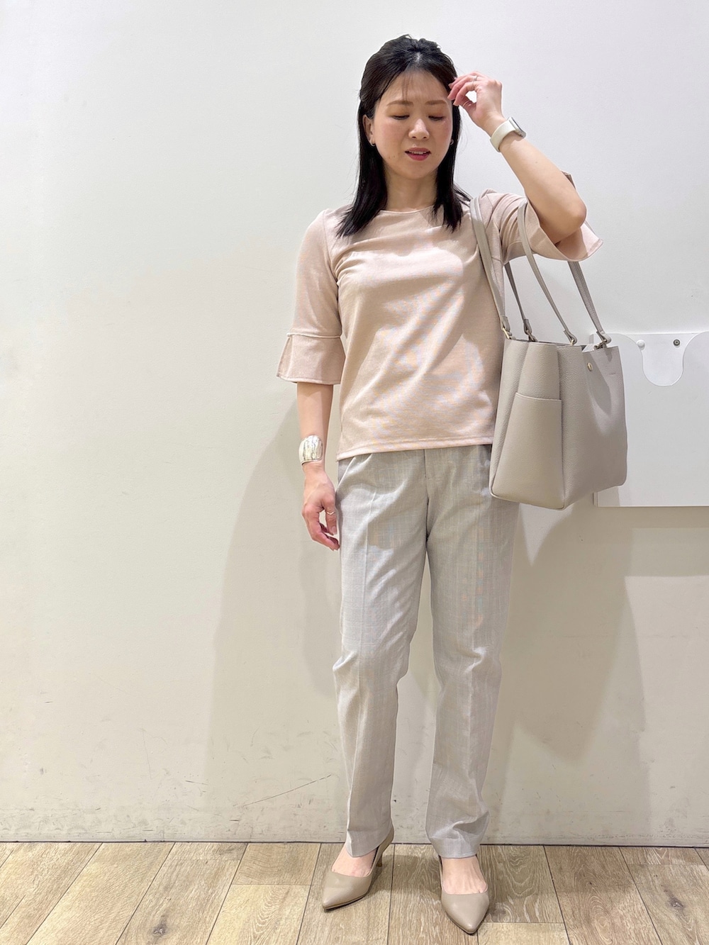 ベージュ系のパンプス、グレー系のカーディガン/ボレロ、ベージュ系のトートバッグを着用したレディースの春コーディネートの6枚目の写真