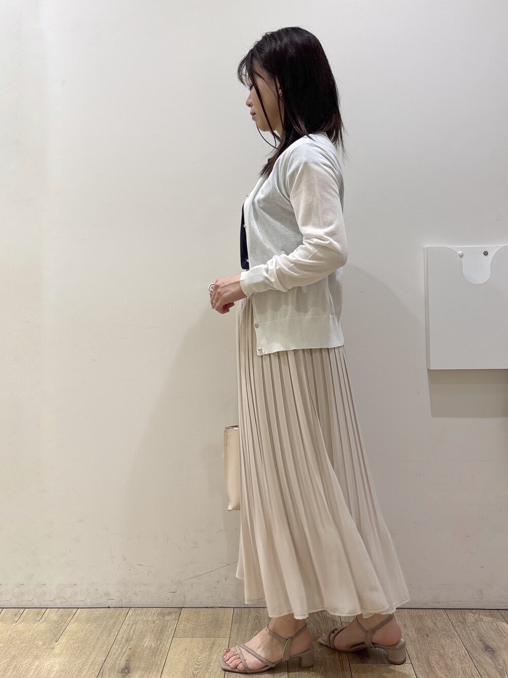 ホワイト系のカーディガン/ボレロ、ブルー系のTシャツ/カットソー、ベージュ系のスカートを着用したレディースの春コーディネートの4枚目の写真