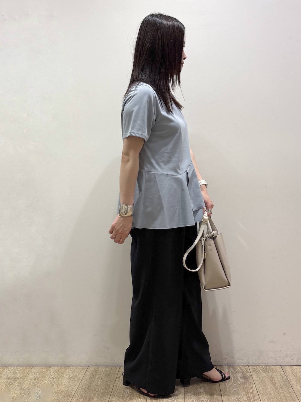 ブルー系のTシャツ/カットソー、ブラック系のその他パンツ、ベージュ系のトートバッグを着用したレディースの夏コーディネートの2枚目の写真