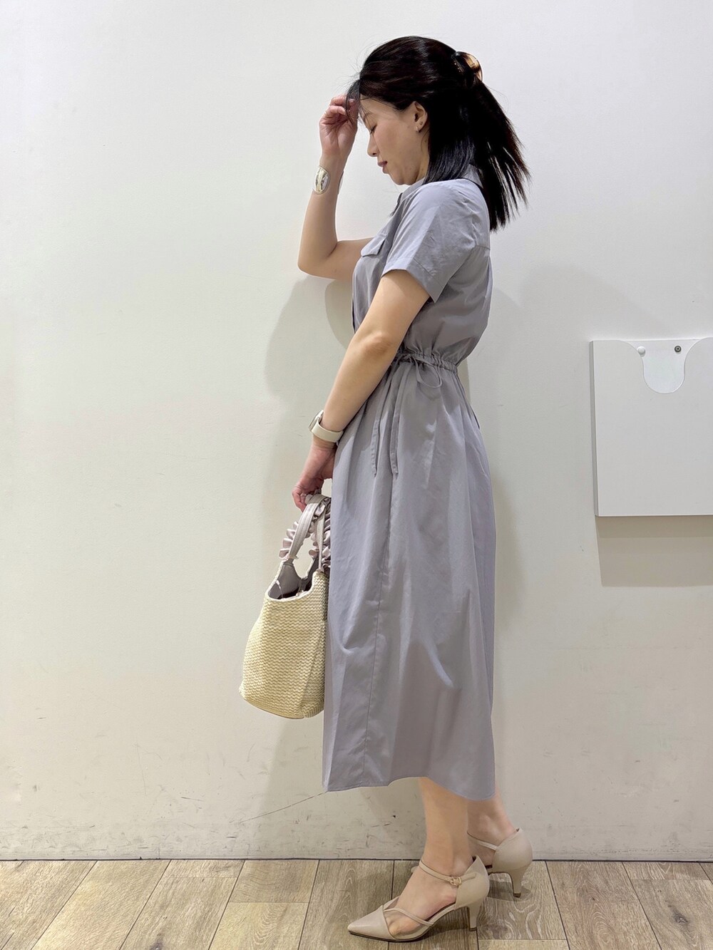 グレー系のワンピース、ベージュ系のトートバッグ、ベージュ系のパンプスを着用したレディースの春コーディネートの4枚目の写真