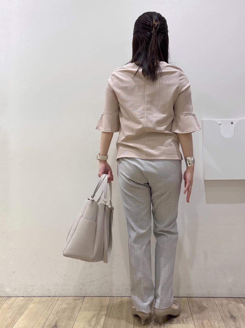 ベージュ系のパンプス、グレー系のカーディガン/ボレロ、ベージュ系のトートバッグを着用したレディースの春コーディネートの3枚目の写真