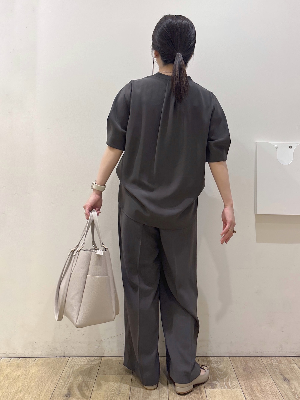 ベージュ系のパンプス、グレー系のカーディガン/ボレロ、ベージュ系のトートバッグを着用したレディースの春コーディネートの3枚目の写真