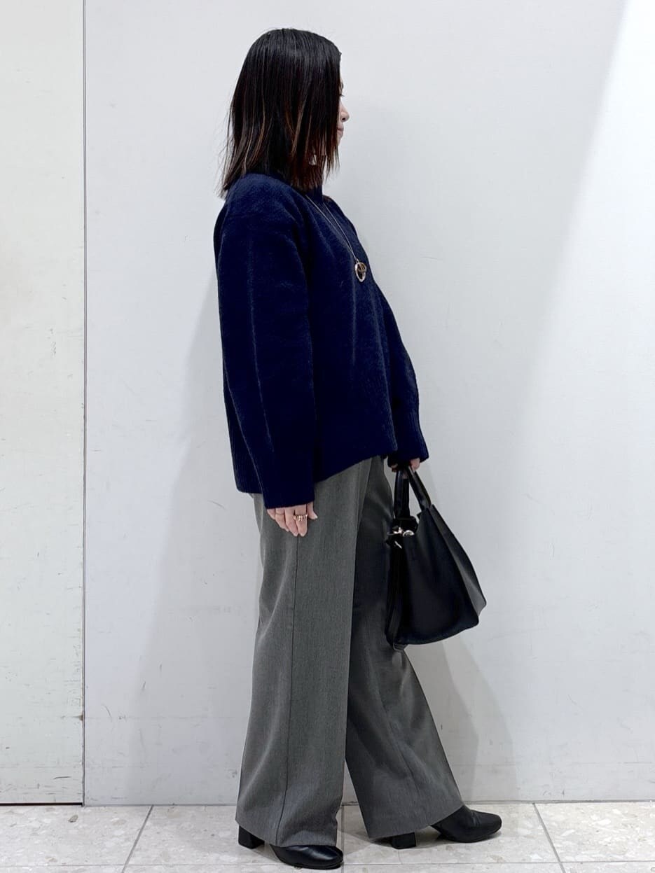 ブルー系のニット/セーター、グレー系のその他パンツ、ブラック系のショルダーバッグを着用したレディースの冬コーディネートの2枚目の写真