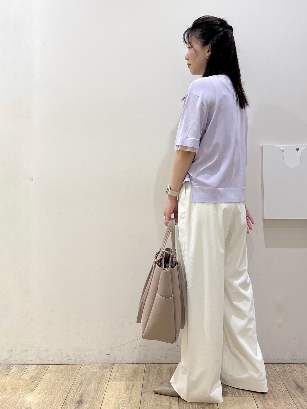 パープル系のニット/セーター、ホワイト系のその他パンツ、ベージュ系のトートバッグを着用したレディースの春コーディネートの4枚目の写真