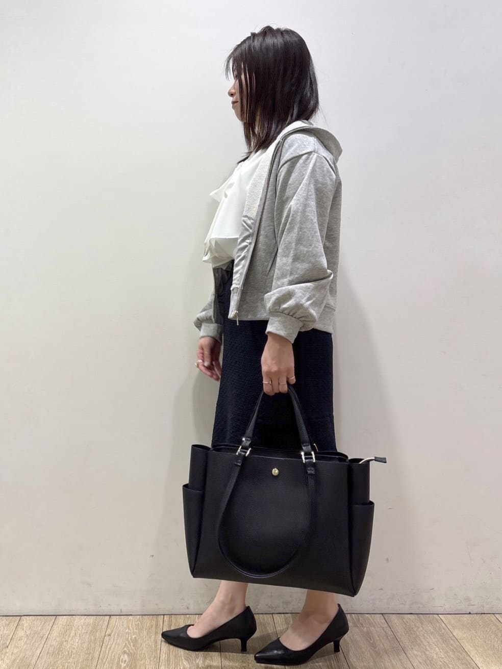 グレー系のパーカー、ホワイト系のシャツ/ブラウス、ブルー系のスカートを着用したレディースの冬コーディネートの4枚目の写真