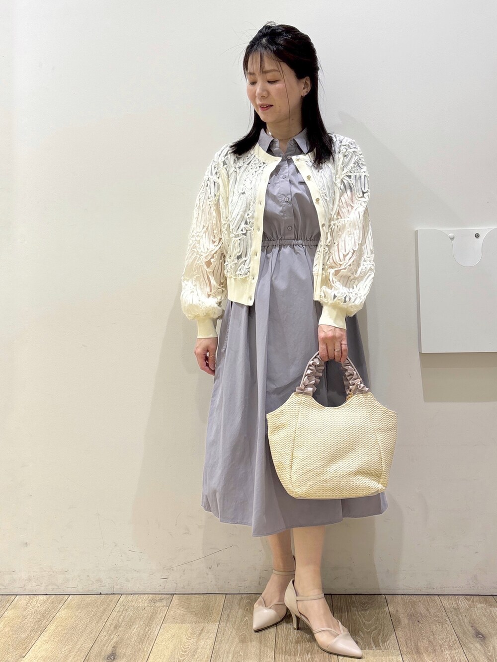 グレー系のワンピース、ベージュ系のトートバッグ、ベージュ系のパンプスを着用したレディースの春コーディネートの7枚目の写真