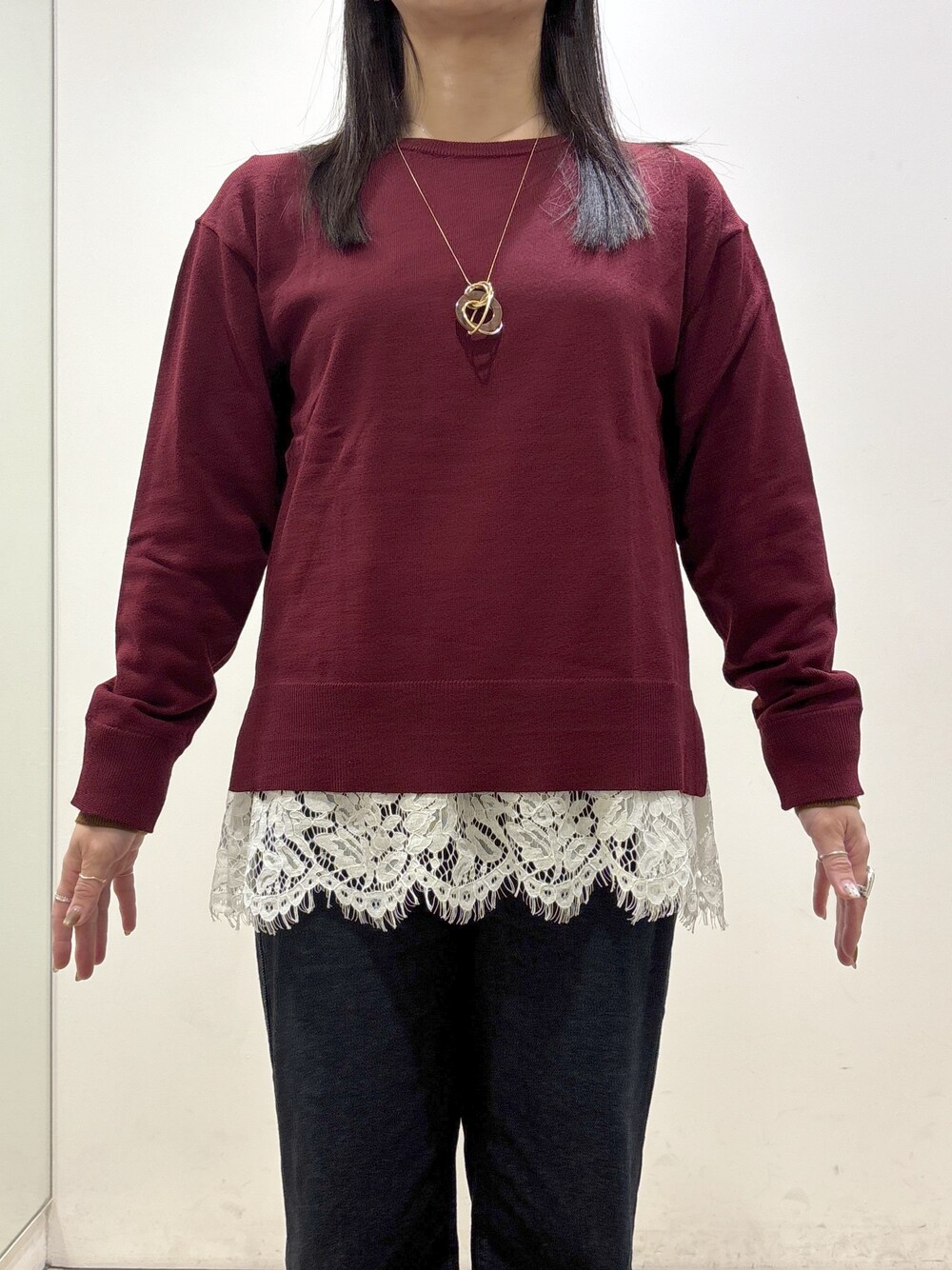 ブラウン系のノーカラーコート、レッド系のニット/セーター、ホワイト系のTシャツ/カットソーを着用したレディースの秋コーディネートの7枚目の写真