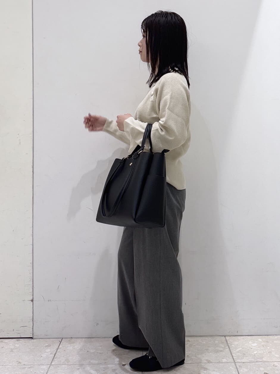 ブラック系のステンカラーコート、ホワイト系のニット/セーター、グレー系のその他パンツを着用したレディースの冬コーディネートの7枚目の写真