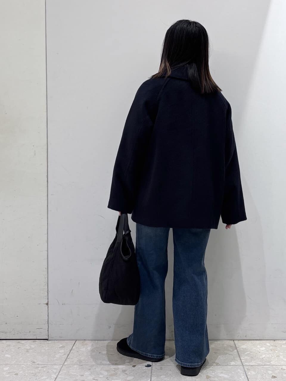 ブルー系のピーコート、グレー系のニット/セーター、ホワイト系のTシャツ/カットソーを着用したレディースの冬コーディネートの3枚目の写真