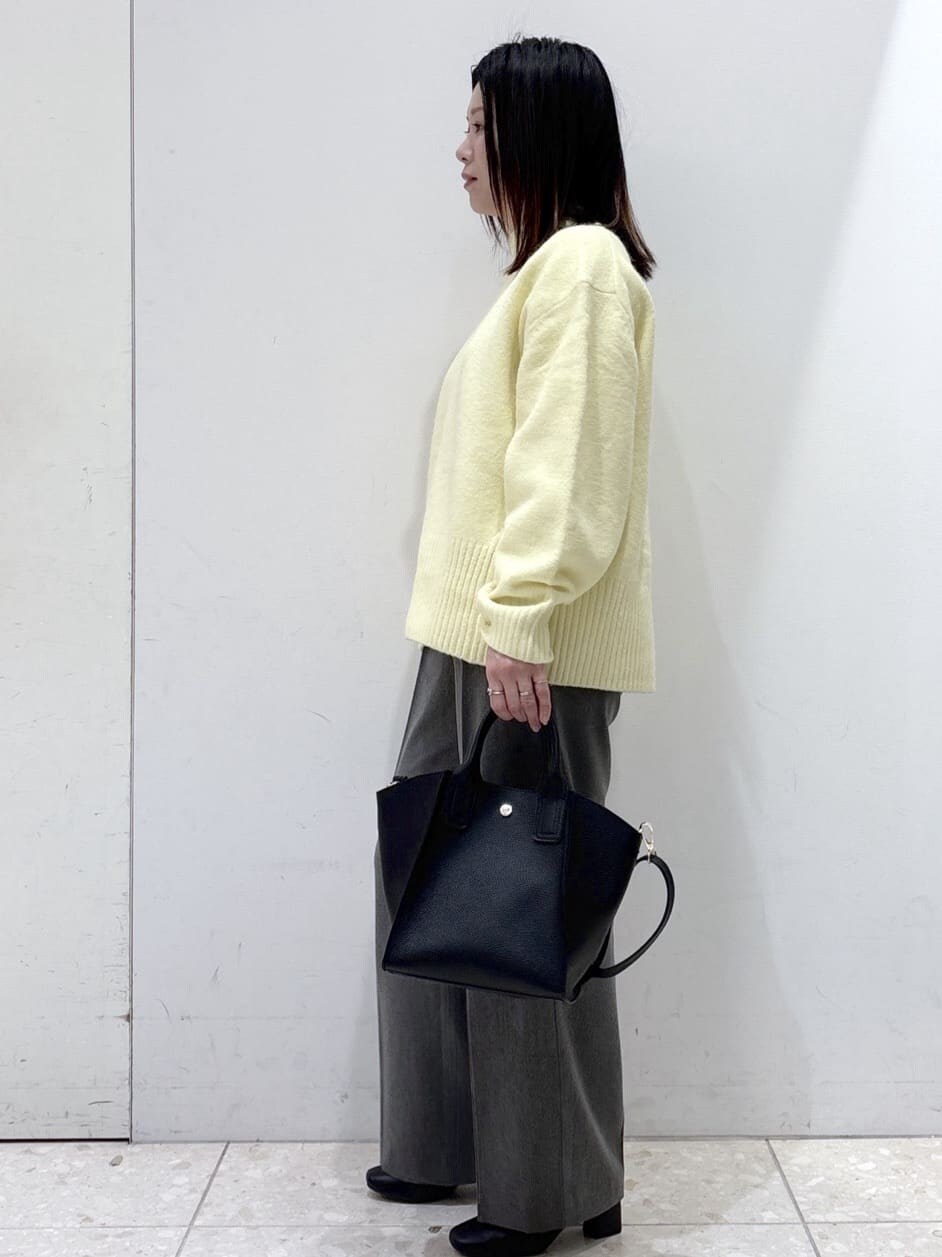 イエロー系のニット/セーター、グレー系のその他パンツ、ブラック系のショルダーバッグを着用したレディースの冬コーディネートの5枚目の写真