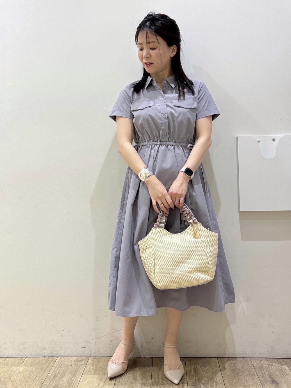 グレー系のワンピース、ベージュ系のトートバッグ、ベージュ系のパンプスを着用したレディースの春コーディネートの5枚目の写真