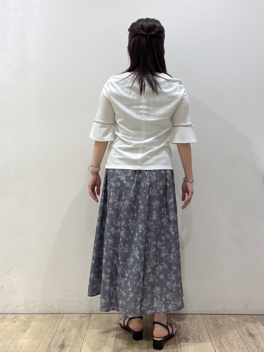 ブラック系のサンダル、ホワイト系のTシャツ/カットソー、グレー系のスカートを着用したレディースの春コーディネートの7枚目の写真