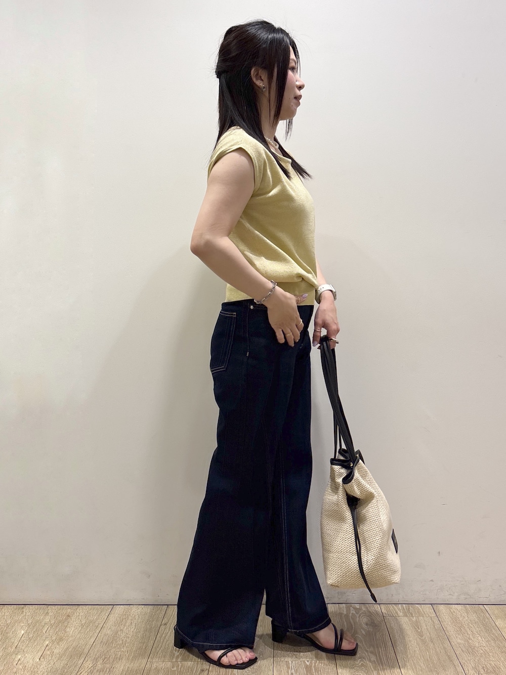 イエロー系のニット/セーター、ブルー系のその他パンツ、ホワイト系のトートバッグを着用したレディースの夏コーディネートの2枚目の写真