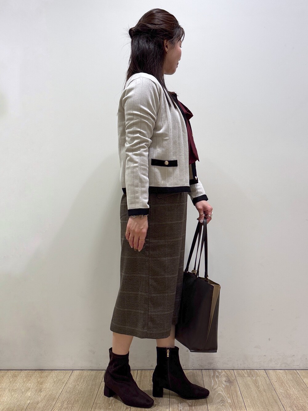 ベージュ系のカーディガン/ボレロ、レッド系のシャツ/ブラウス、ブラウン系のスカートを着用したレディースの秋コーディネートの2枚目の写真