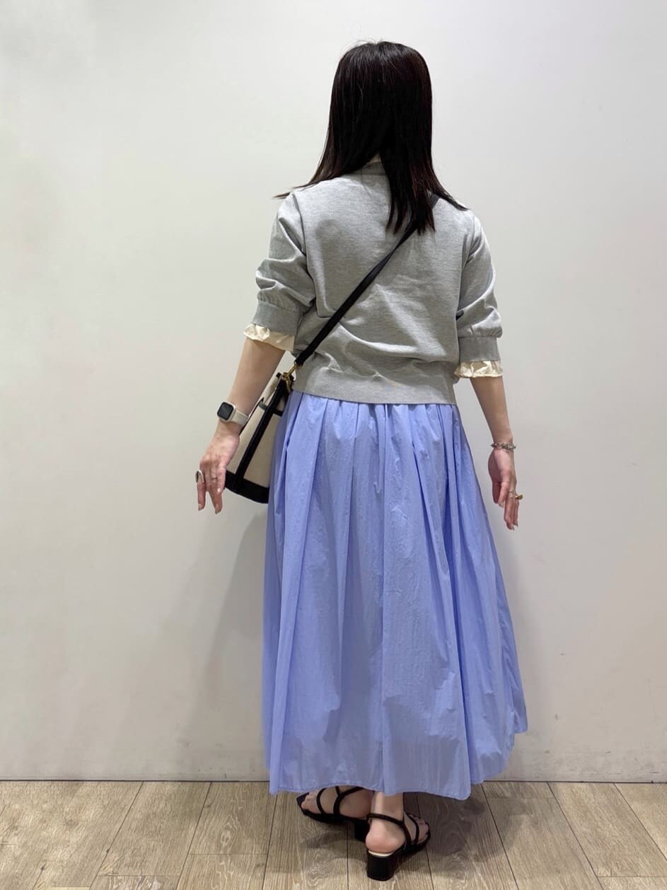 ブルー系のスカート、ブラック系のサンダル、ブラック系のショルダーバッグを着用したレディースの春コーディネートの6枚目の写真