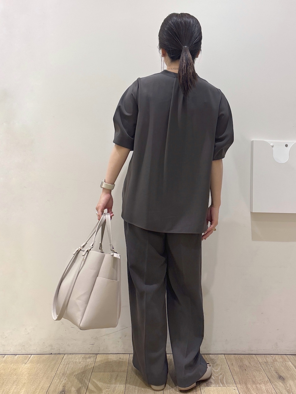 ベージュ系のパンプス、グレー系のカーディガン/ボレロ、ベージュ系のトートバッグを着用したレディースの春コーディネートの3枚目の写真