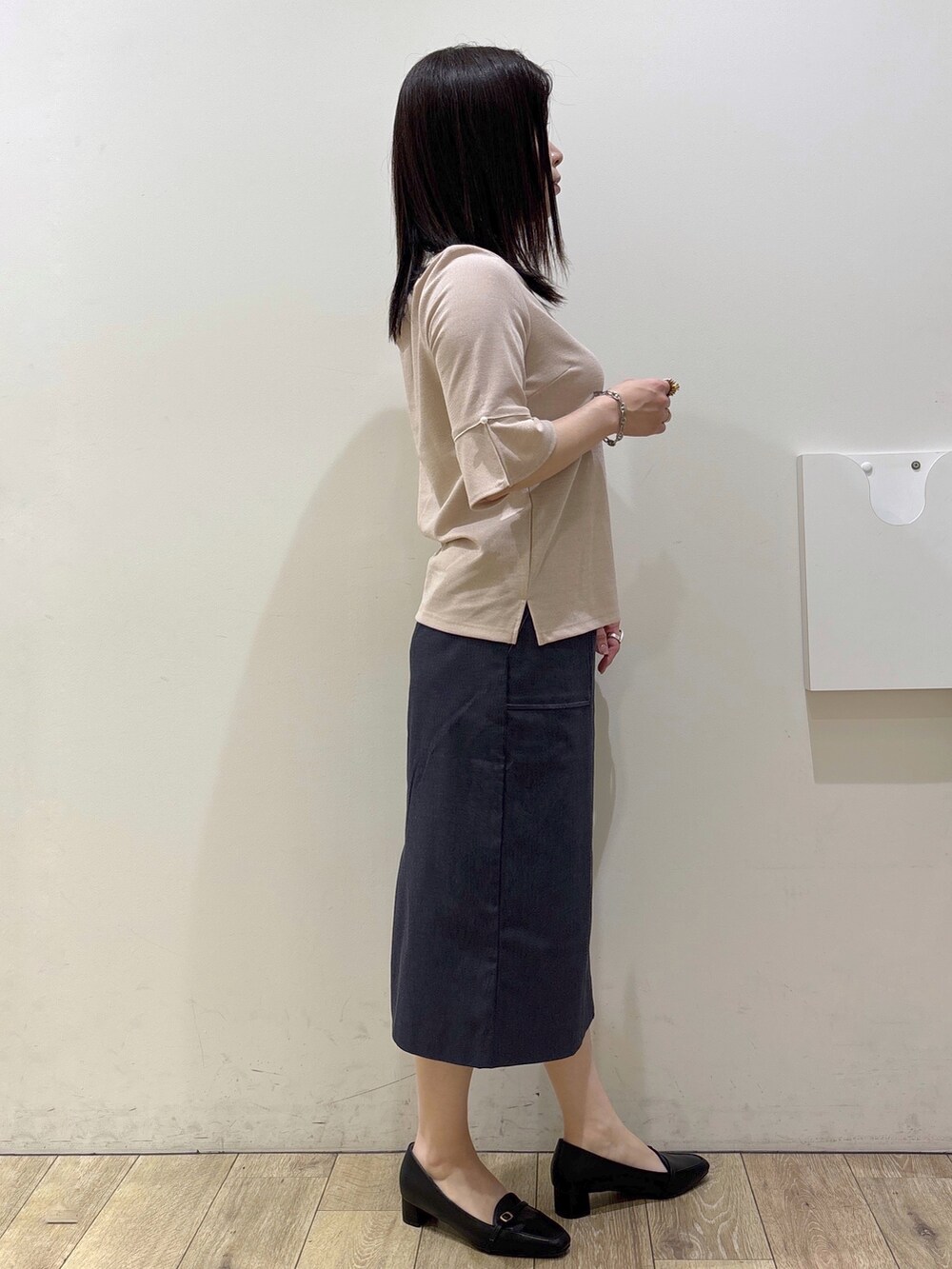 ブラック系のパンプス、ブラック系のトートバッグ、ブルー系のスカートを着用したレディースの春コーディネートの9枚目の写真