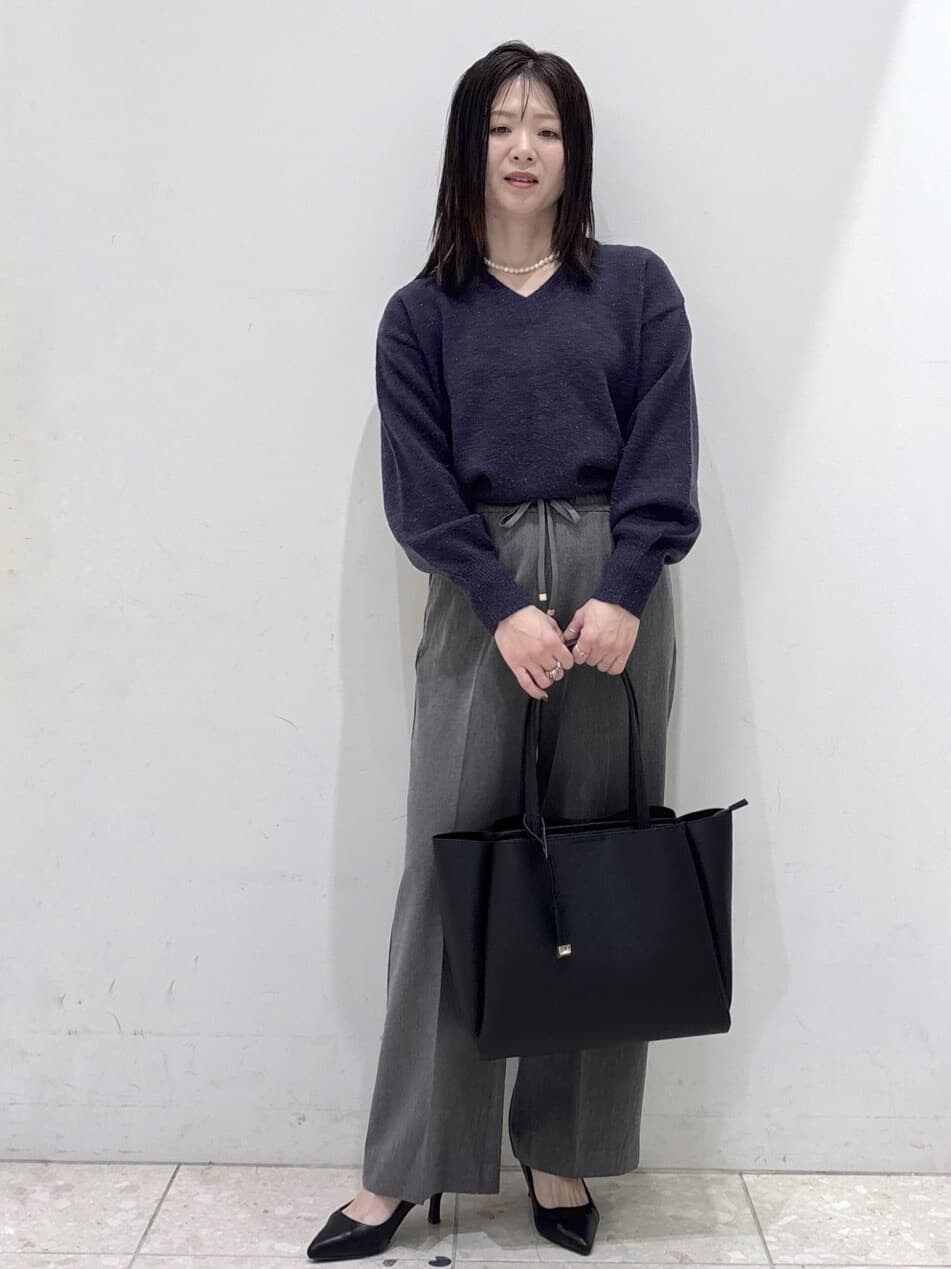 ブルー系のニット/セーター、グレー系のその他パンツ、ブラック系のトートバッグを着用したレディースの冬コーディネートの6枚目の写真