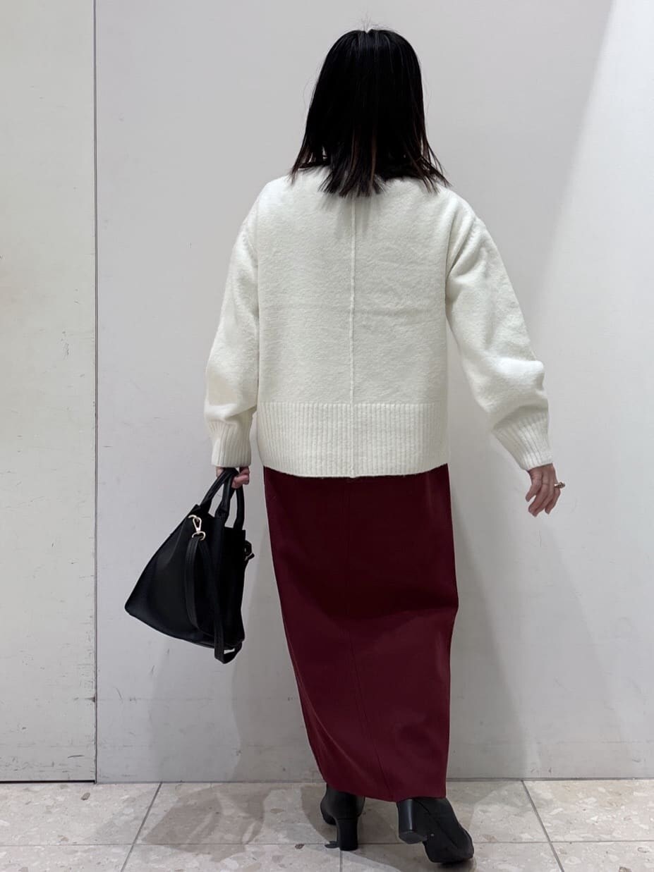 ホワイト系のニット/セーター、レッド系のスカート、ブラック系のショルダーバッグを着用したレディースの冬コーディネートの4枚目の写真