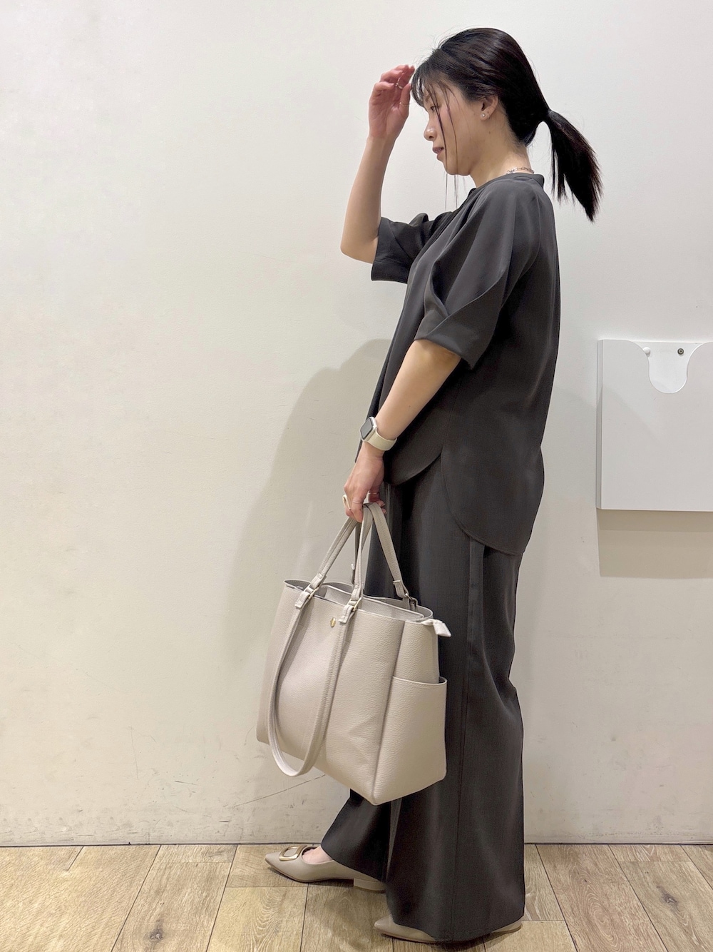 ベージュ系のパンプス、グレー系のカーディガン/ボレロ、ベージュ系のトートバッグを着用したレディースの春コーディネートの4枚目の写真