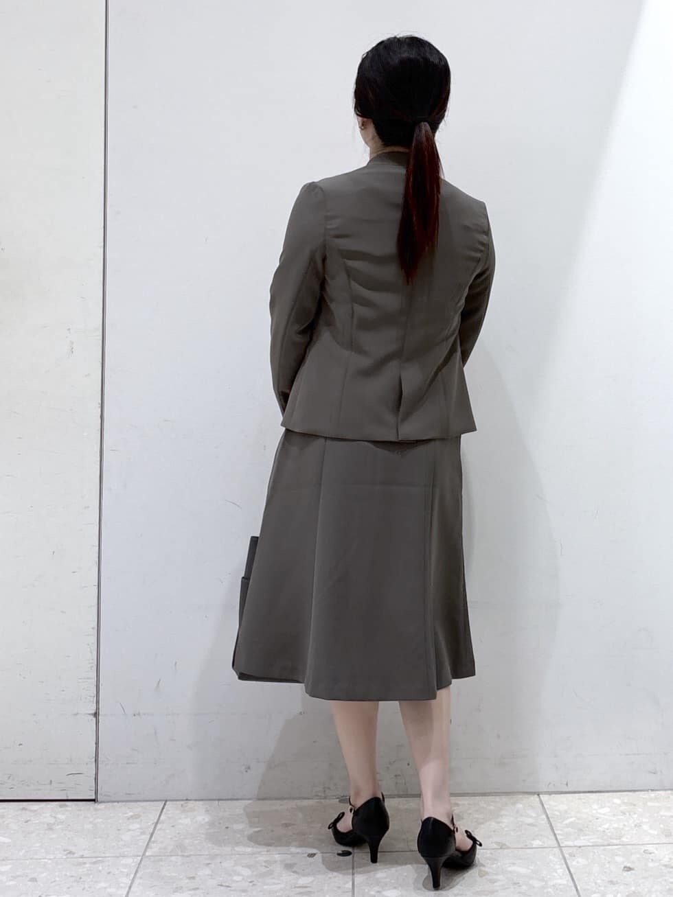ブラウン系のノーカラージャケット、ホワイト系のシャツ/ブラウス、ブラウン系のスカートを着用したレディースの秋コーディネートの3枚目の写真