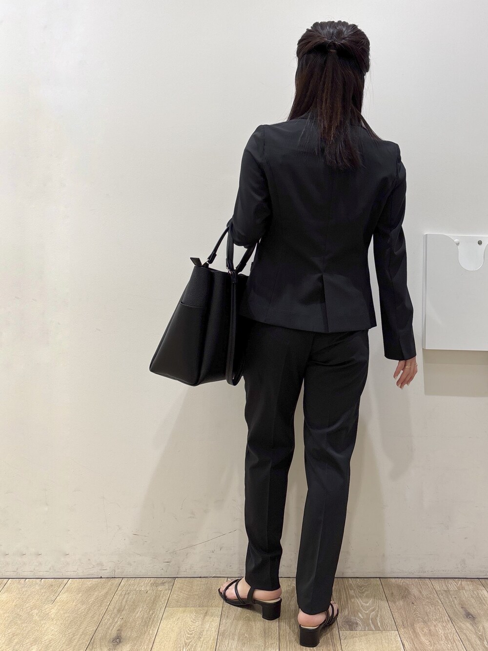 ブラック系のテーラードジャケット、ピンク系のTシャツ/カットソー、ブラック系のその他パンツを着用したレディースの春コーディネートの3枚目の写真