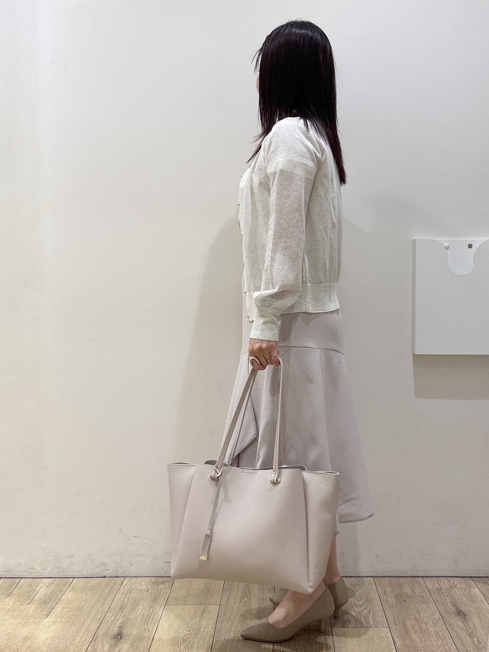 ホワイト系のカーディガン/ボレロ、ホワイト系のシャツ/ブラウス、ベージュ系のスカートを着用したレディースの夏コーディネートの3枚目の写真