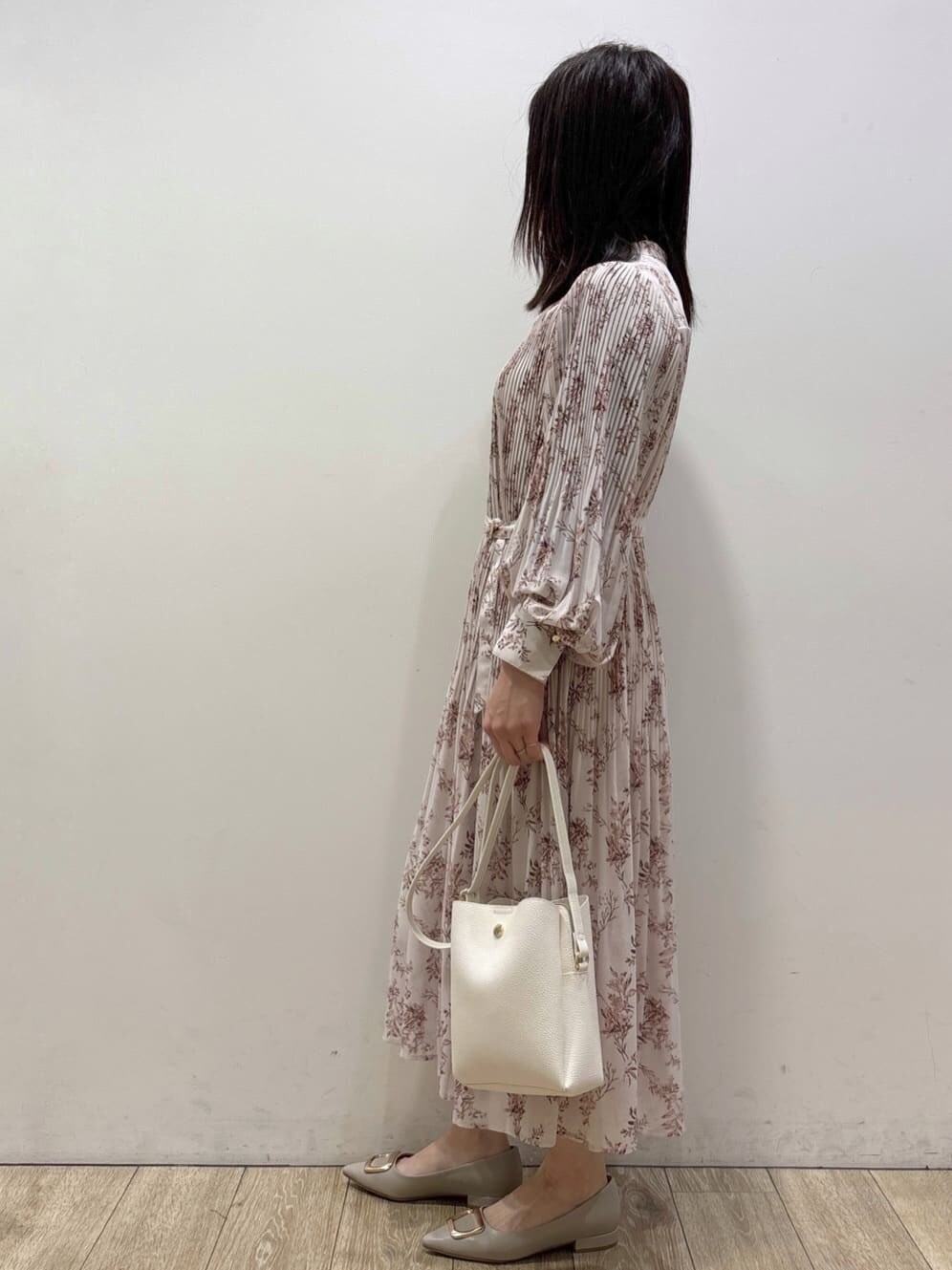ホワイト系のショルダーバッグ、ベージュ系のパンプス、レッド系のスカートを着用したレディースの冬コーディネートの4枚目の写真