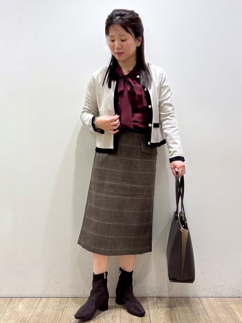ベージュ系のカーディガン/ボレロ、レッド系のシャツ/ブラウス、ブラウン系のスカートを着用したレディースの秋コーディネートの5枚目の写真