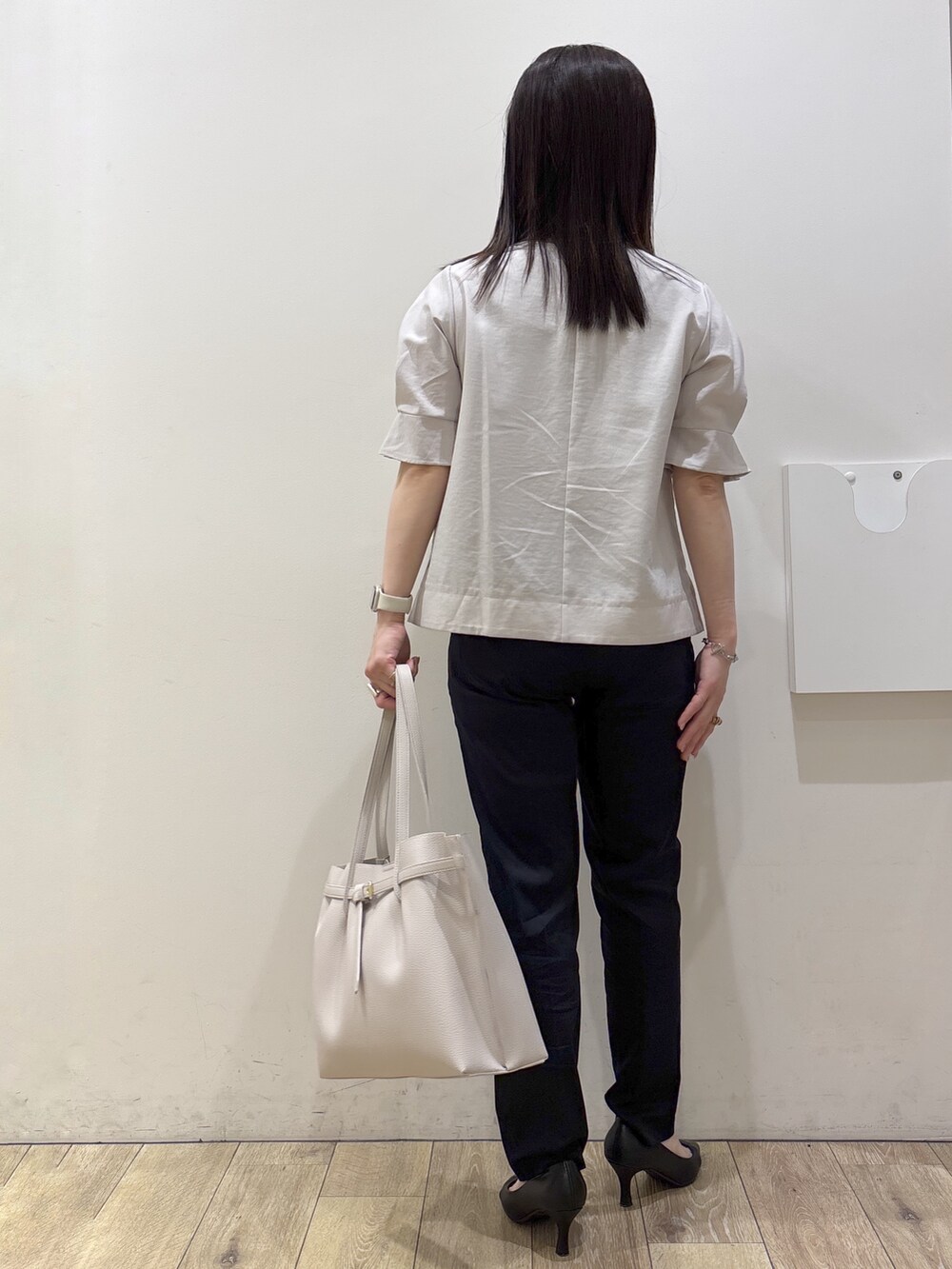 ブラック系のパンプス、グレー系のトートバッグ、ブルー系のその他パンツを着用したレディースの春コーディネートの3枚目の写真
