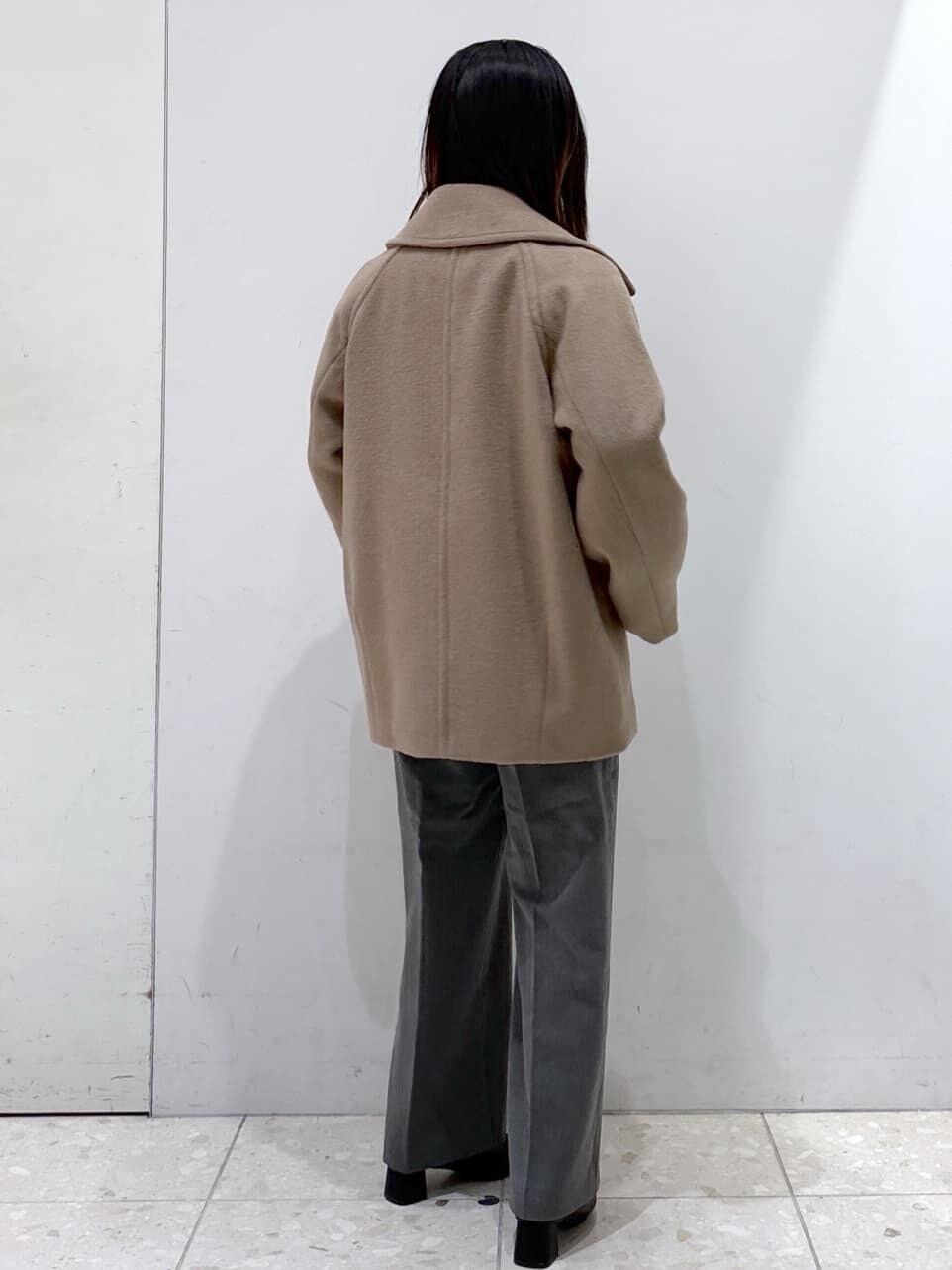 ブルー系のニット/セーター、グレー系のその他パンツ、ブラック系のトートバッグを着用したレディースの冬コーディネートの7枚目の写真