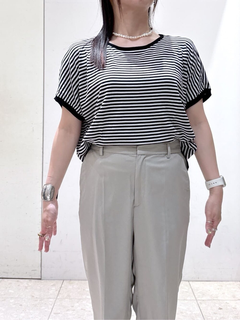 ブラック系のニット/セーター、ブラウン系のその他パンツ、ブラック系のトートバッグを着用したレディースの夏コーディネートの5枚目の写真