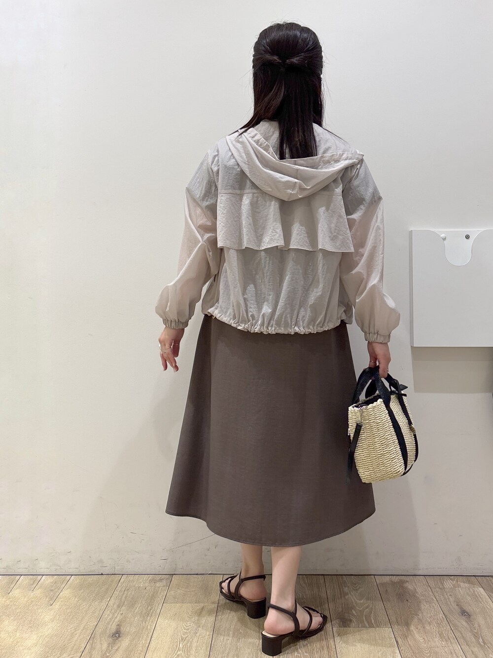 ベージュ系のブルゾン、ブラウン系のワンピース、ブラック系のトートバッグを着用したレディースの春コーディネートの3枚目の写真