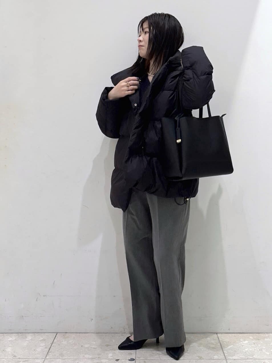 ブラック系のダウンジャケット/コート、ブルー系のニット/セーター、グレー系のその他パンツを着用したレディースの冬コーディネートの5枚目の写真