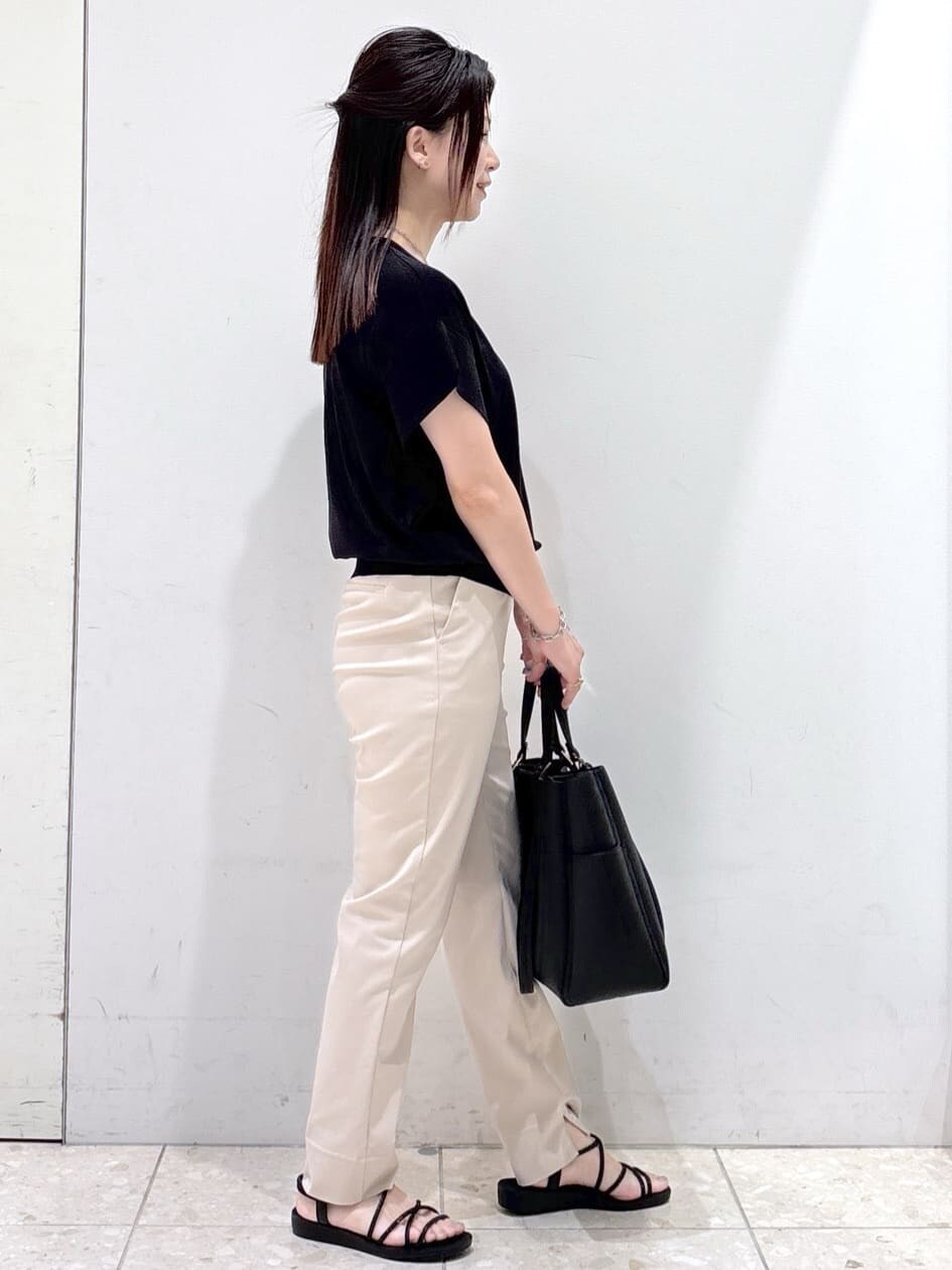 ブラック系のニット/セーター、ベージュ系のその他パンツ、ブラック系のトートバッグを着用したレディースの夏コーディネートの2枚目の写真
