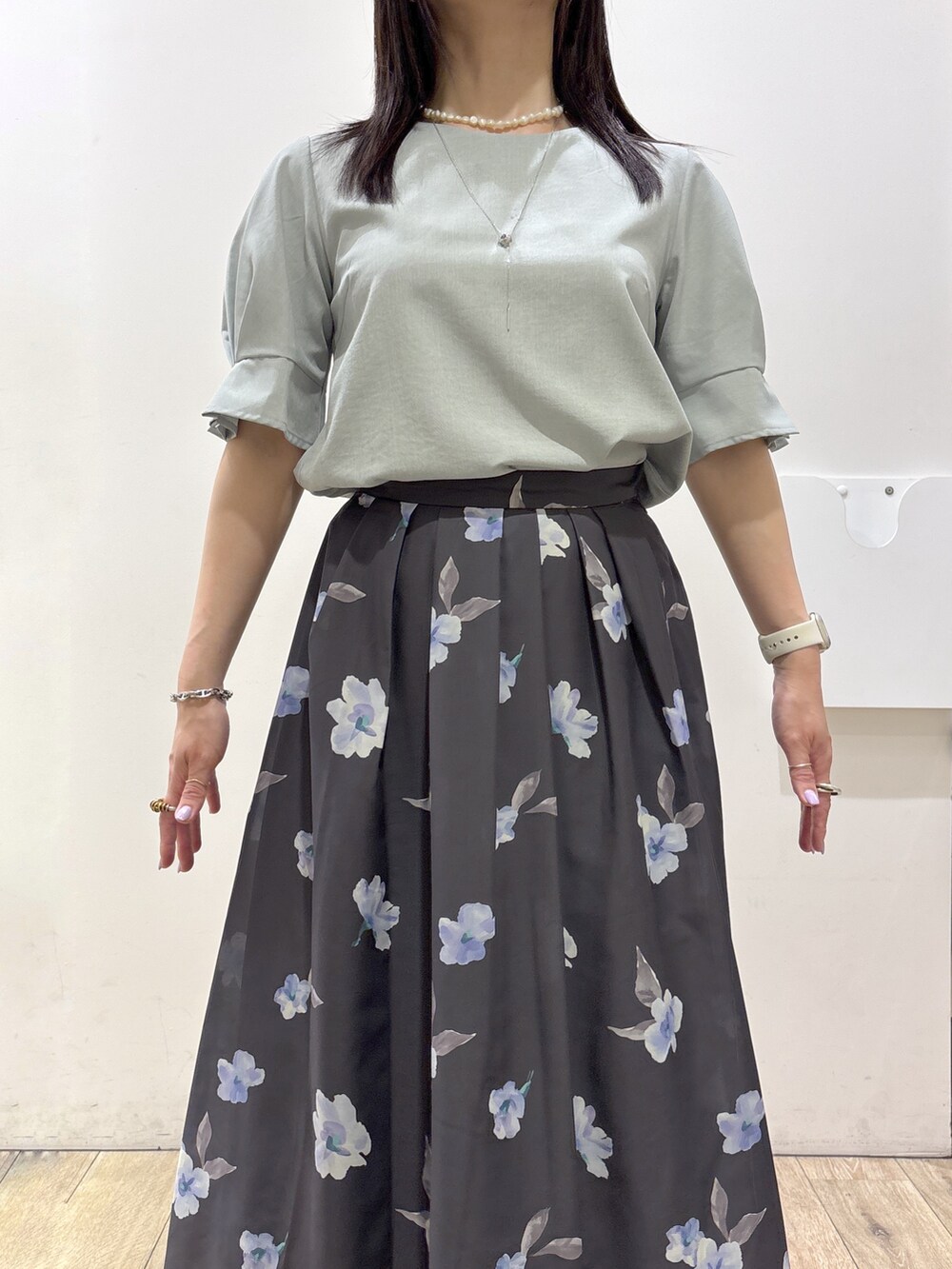 グレー系のスカート、ホワイト系のトートバッグ、ベージュ系のサンダルを着用したレディースの夏コーディネートの6枚目の写真