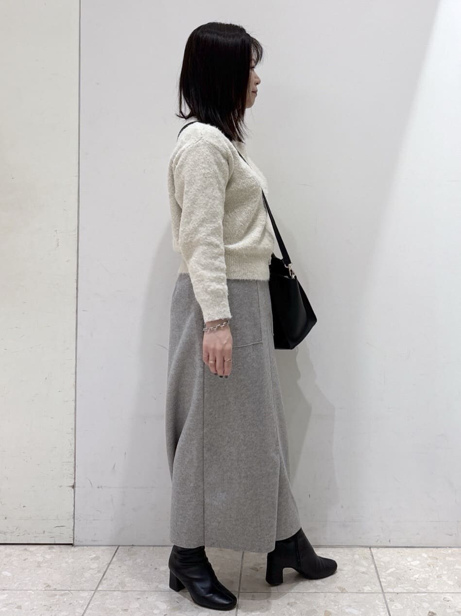 ベージュ系のニット/セーター、グレー系のスカート、ブラック系のショルダーバッグを着用したレディースの冬コーディネートの2枚目の写真
