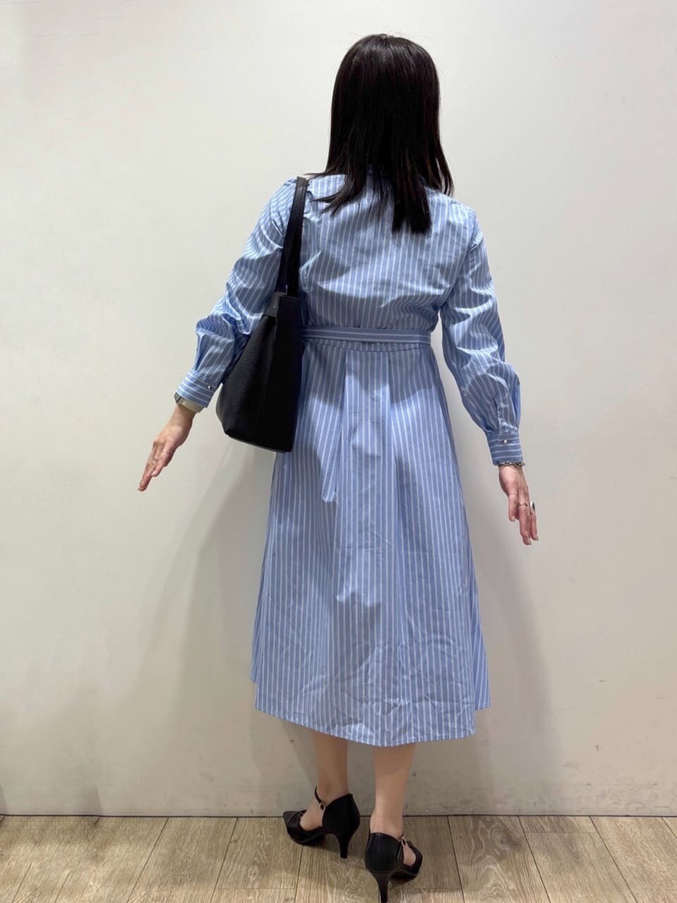 ブラック系のパンプス、ブルー系のワンピース、ブラック系のトートバッグを着用したレディースの春コーディネートの3枚目の写真