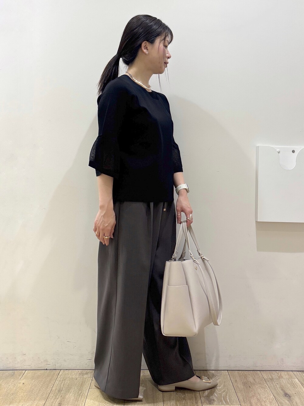 ベージュ系のパンプス、グレー系のカーディガン/ボレロ、ベージュ系のトートバッグを着用したレディースの春コーディネートの2枚目の写真